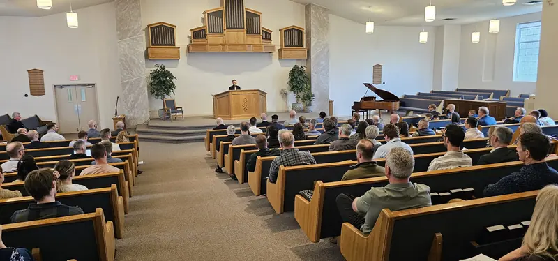 Attendees seated in the pews of the host church sanctuary during a conference session